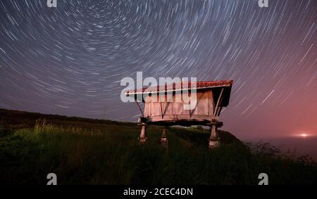 Langzeitaufnahme eines herrlichen Sternenhimmels über einer kleinen Hütte In schöner Natur in der Nacht Stockfoto