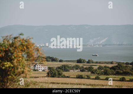 Die Landschaft mit dem großen Frachtschiff kommt in die Industriehafen an der Donau auf dem serbien rumänisch Grenze während des sonnigen Sommertages Stockfoto