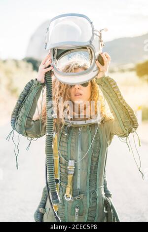 Schöne Frau, die den Helm als Astronaut angezogen hat. Stockfoto