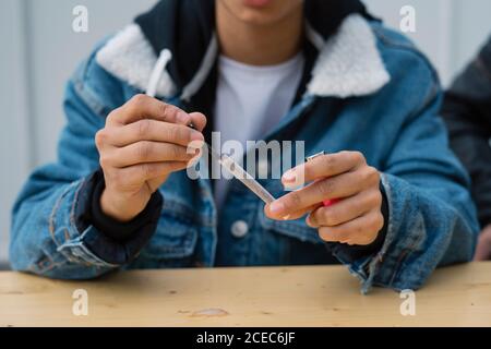 Junge Frau rollt Zigarette Stockfoto