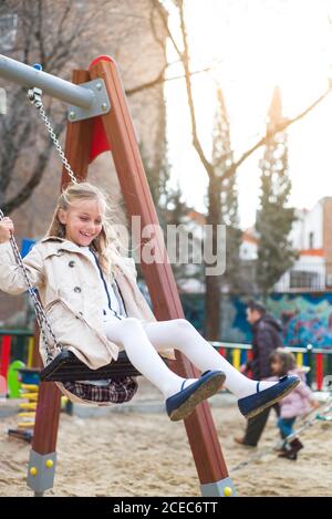 Fröhliche junge Mädchen mit Spaß und Schaukeln im Park. Stockfoto