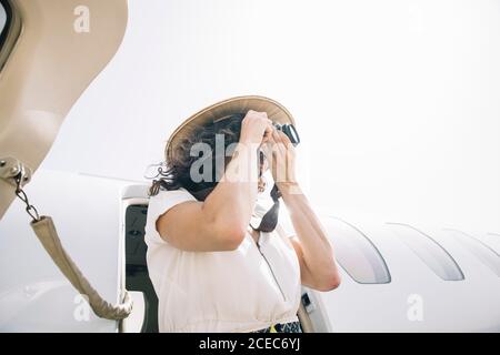 Pretty Woman senkt ein Flugzeug im Freien und macht Fotos. Stockfoto