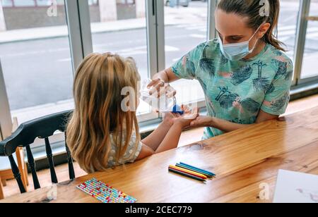 Mutter, die Desinfektionsmittel Gel auf Tochter Stockfoto