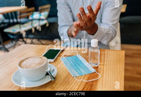 Nicht erkennbarer Mann, der seine Hände mit hydroalkoholischem Gel desinfiziert Stockfoto