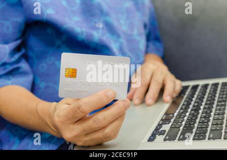 Senioren Frau mit Kreditkarten auf Laptop. Stockfoto