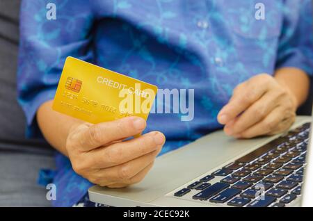 Senioren Frau mit Kreditkarten auf Laptop. Stockfoto