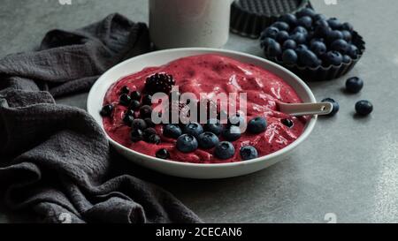 Smoothy von frischen Heidelbeeren und Himbeeren in der Schüssel in der Nähe von Serviette bog Stockfoto