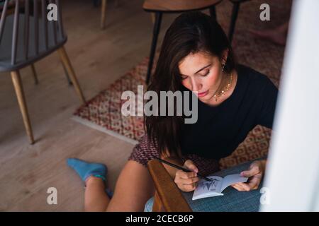 Junge Brünette Frau im Zimmer sitzen Stockfoto