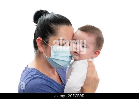 Mutter trägt medizinische oder chirurgische covid19 Influenza-Prävention Maske zu Schützen Baby Mädchen Tochter beim Umarmung als Familie Liebe Pandemie Concept isola Stockfoto