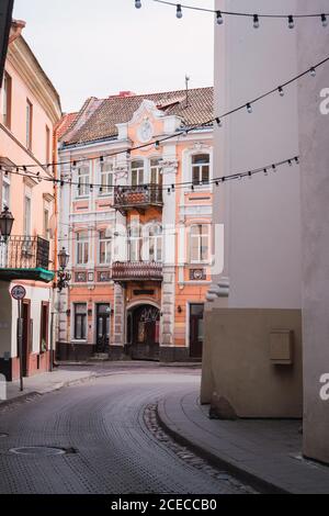 Girlanden mit Glühbirnen hängen zwischen schönen Gebäuden auf schmal Straße der Altstadt Stockfoto