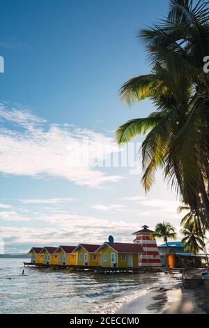 Malerischer Blick auf kleine bunte Häuser an der tropischen Küste mit Palmen, Panama Stockfoto