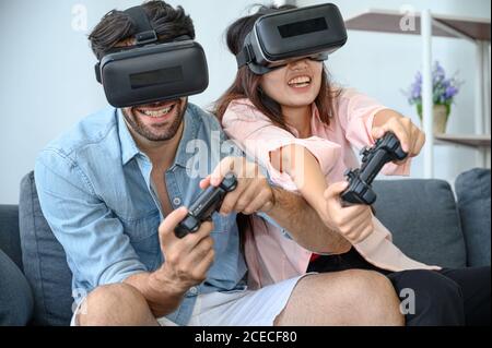 Paare Liebhaber genießen es, VR-Spiel zusammen zu Hause zu spielen. Familienbeziehungskonzept. Stockfoto