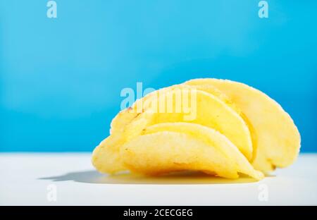 Kartoffelchips oder Chips auf farbigem Hintergrund, schöne Scheiben Bratkartoffeln Stockfoto