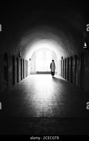 Silhouette einer nicht erkennbaren schlafwandenden Frau in einer mittelalterlichen psychiatrischen Klinik Stockfoto