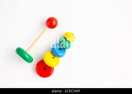 Pyramide aus farbigen Holzringen auf weißem Hintergrund. Kindergarten pädagogische Spielzeug, Denkprozess. Speicherplatz kopieren. Stockfoto