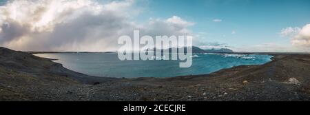 Atemberaubende Luftaufnahme der blauen Meer Berge und Wolken in Panoramaformat Stockfoto