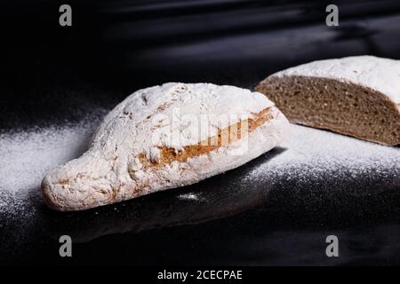 Graues Brot mit Mehl bestreut. Hausgemachtes Gebäck, Brot geschnitten gavpil Stockfoto