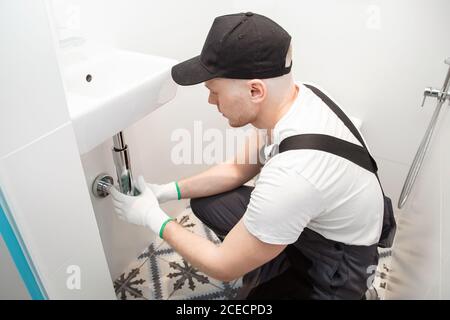 Männliche Klempner setzt Chrom Abfluss für Wasser unter Waschbecken Stockfoto