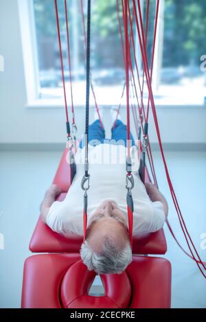 Älterer Mann über Couch im medizinischen Zentrum in der Rehabilitation Stockfoto