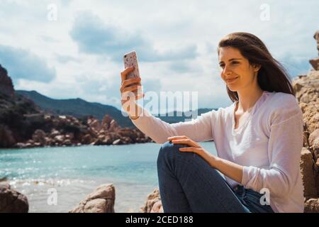 Frau nimmt Selfie mit Smartphone am Meer Stockfoto