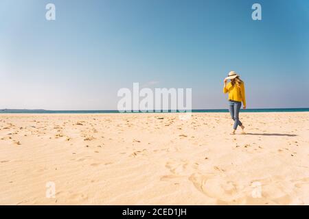 Frau, die am Sandstrand steht Stockfoto
