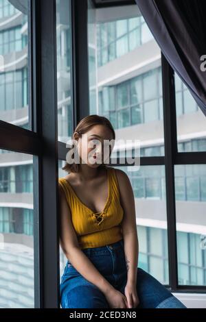 Frau mit Tasse am Fenster Stockfoto