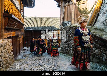 GUINZHOU, CHINA - 14. JUNI 2018: Miao Frauen, die in traditionellen Kostümen spazieren Stockfoto