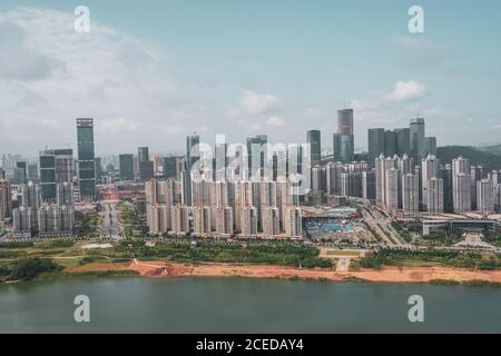 Luftaufnahme der modernen Hochhausstadt Nanning an der Uferlinie des Flusses mit grüner Vegetation, Guangxi, China Stockfoto