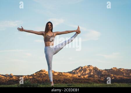 Frau streckt sich auf dem Feld Stockfoto