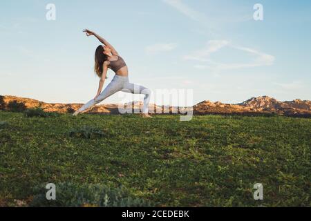Frau, die Yoga auf dem Feld macht Stockfoto