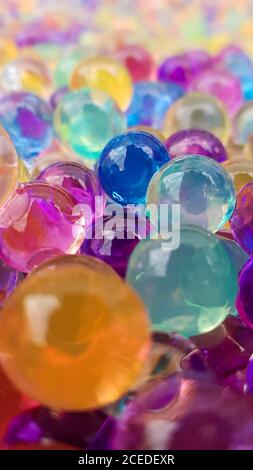 Viele verschiedene farbige Hydrogelkugeln. Set von mehrfarbigen orbis. Kristallwasserperlen für Spiele. Heliumballons. Kann als Hintergrund verwendet werden. Poly Stockfoto