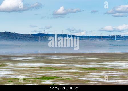 Niedrige Wolken und Windturbinen spiegeln sich im kürzlich neu aufgefüllten Lake George in der Nähe von Canberra, ACT, Australien. Der See ist seit vielen Jahren trocken. Stockfoto