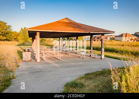 Picknicktische in einem Pavillon sind gemeinsame Treffpunkte in Der Sommer Stockfoto