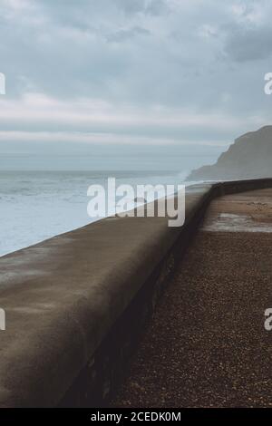 Perspektivischer Blick auf gepflasterte Küste mit schaumigen stürmischen Wellen des Ozeans im Hintergrund, San Sebastian Stockfoto