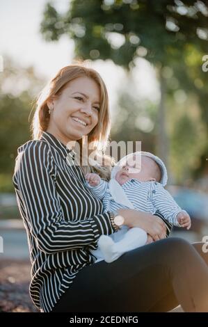 Junge Mutter umarmt sein Baby mit Down-Syndrom Stockfoto