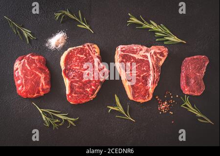 Verschiedene Rindersteaks auf dunklem Hintergrund Stockfoto