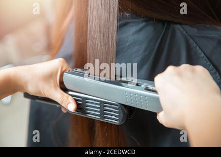 Keratin Erholung und Behandlung mit professionellen Eisen-Tool. Laminiert lange dunkel glänzend Haar Nahaufnahme Stockfoto