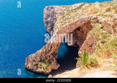 Blaue Grotte auf Malta. Vergnügungsboot mit Touristen fährt. Naturbogenfenster in Felsen Stockfoto