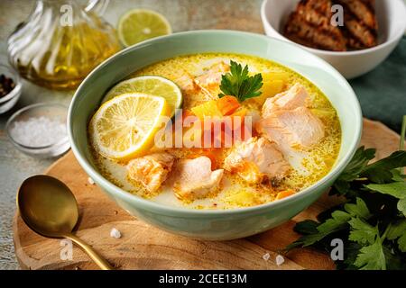 Nahaufnahme eines grünen Tellers mit köstlichem Lachsfisch Suppe mit Gemüsecreme Stockfoto