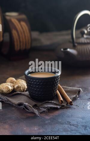 Orientalische Tasse Tee Chai, seine Zutaten mit Milch, Zimt, Ingwer, weißem Pfeffer und Kardamom Stockfoto