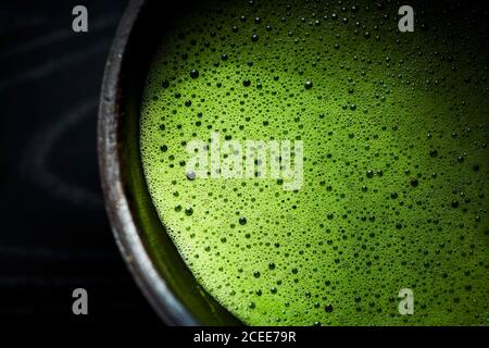 Eine schwarze Schale Matcha mit grünem Schaum auf der Oberseite. Stockfoto