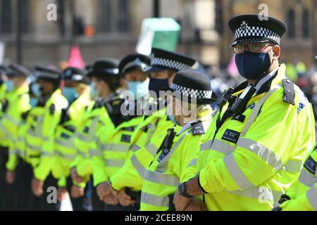Polizeibeamte mit Gesichtsmasken während einer Rebellion-Protestaktion am Parliament Square, Westminster, London. Stockfoto