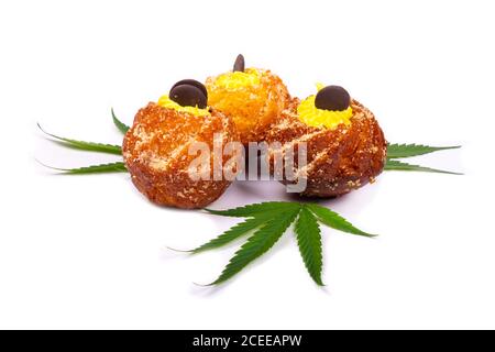 Frische süße Backwaren mit Marihuana, drei Cupcakes mit Cannabispflanzenblättern isoliert auf weißem Hintergrund, Süßigkeiten, Dessert. Stockfoto