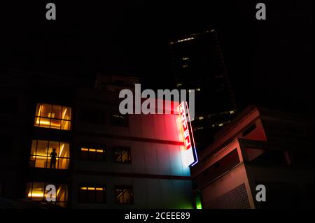 Von unten ein Bild des Hotelgebäudes mit einem Neonschild, das in der Nacht leuchtet. Stockfoto