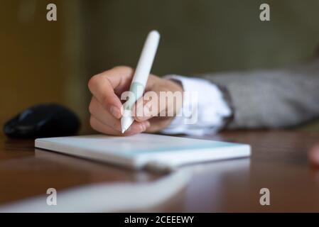 Geschäftsmann sitzt am Tisch, Zeichen in einer Grafik-Tablet mit einem Stift. Nahaufnahme. Unternehmen. Elektronische Signatur mit einem Stifttablett Stockfoto