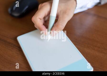 Geschäftsmann sitzt am Tisch, Zeichen in einer Grafik-Tablet mit einem Stift. Nahaufnahme. Unternehmen. Elektronische Signatur mit einem Stifttablett Stockfoto