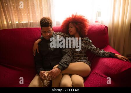 Ethnische Paare mit Sitz auf Couch Stockfoto