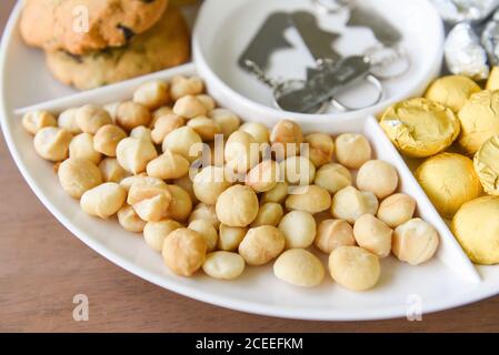 Set von Macadamia Nussverpackung auf Tablett Platte natürliche hoch Protein / Kekse Schokolade mit Macadamia-Nüssen Stockfoto