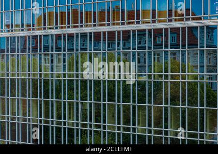 Gerahmte Glaswand des Firmengebäudes in Hamburg Deutschland. Verzerrte Abstraktion der Stadtstraßenspiegelung in Spiegelfläche moderner Architektur Stockfoto