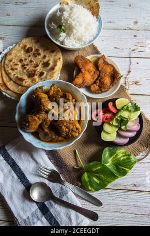 Indische Mahlzeit, fertig zum Essen, serviert in Schüsseln und Tellern Auf einem Hintergrund Stockfoto